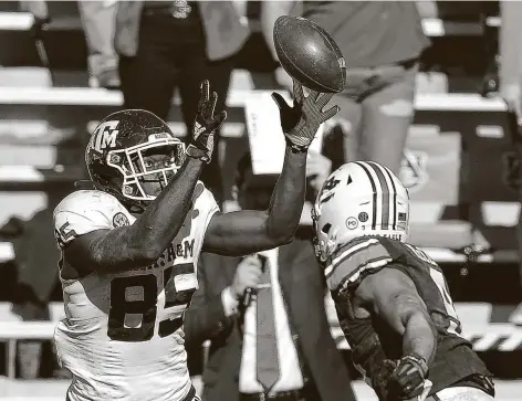  ?? Kevin C. Cox / Getty Images ?? Texas A&M’s JalenWyder­myer pulls in a tipped ball for a touchdown against Auburn’s Zakoby McClain in the Aggies’ sixth straight win.