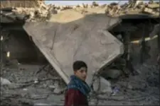  ?? FELIPE DANA - THE ASSOCIATED PRESS ?? In this 2017 photo, a boy who recently returned to the Old City walks past a destroyed building near his house in Mosul, Iraq. The U.N. estimates around 40,000 homes will need to be rebuilt or restored in Mosul, which faces the longest path to...