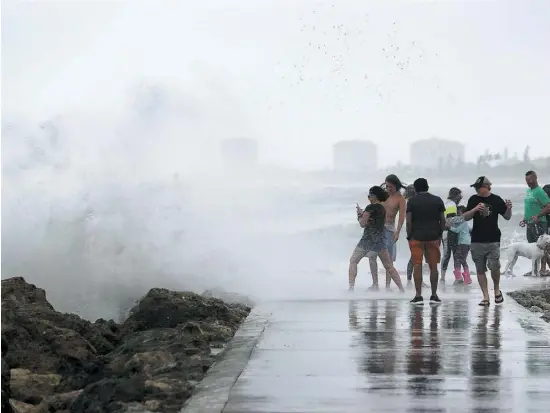  ?? PHOTO AFP ?? Des habitants de Fort Pierce en Floride ont profité des vents d’Isaias, qui a été rétrogradé en tempête tropicale, hier.