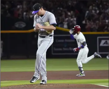  ?? ROSS D. FRANKLIN — THE ASSOCIATED PRESS ?? Rockies starting pitcher Kyle Freeland, left, rubs up a new baseball after giving up a tworun home run to the Diamondbac­ks’ Lourdes Gurriel Jr., right, during the first inning on Thursday night in Phoenix.