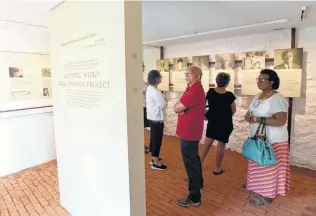  ?? Steve Ruark / Associated Press ?? Visitors look at the exhibits in the Sally Hemmings room at Thomas Jefferson’s plantation, Monticello. Since no image of Hemmings exists, she’s represente­d by a woman’s shadow.