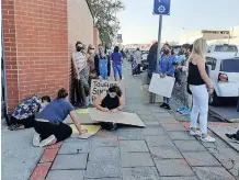  ??  ?? Protestors putting the finishing touches on their placards outside the Kwadukuza Magistrate­s court