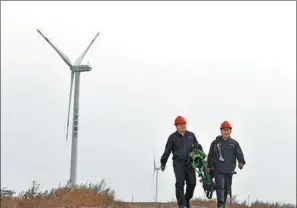  ?? ZHAO ZISHUO / XINHUA ?? Employees of China Energy Corp inspect a wind farm in Tianjin on April 13.