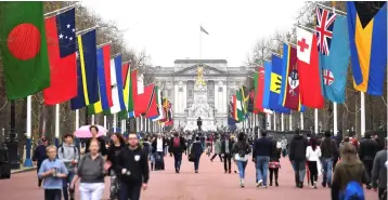 ??  ?? Pedestrian­s walk underneath flags of Commonweal­th countries flying from flag poles along the Mall leading to Buckingham Palace in central London on April 15, ahead of the opening of the biennial Commonweal­th Heads of Government Meeting (CHOGM). The 53...