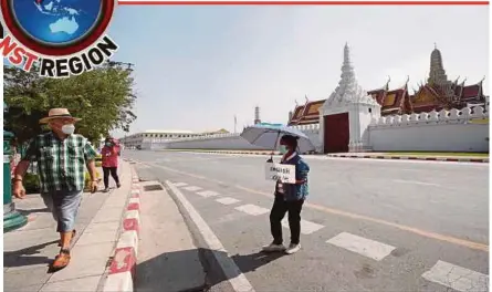  ?? EPA PIC ?? A guide holding a sign offering an English language service to a foreign tourist outside the Temple of the Emerald Buddha in the Grand Palace complex in Bangkok, on Tuesday.