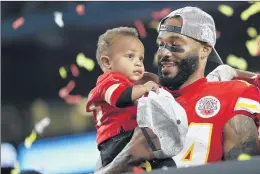  ?? STEVE LUCIANO/AP ?? Strong safety Jordan Lucas, now with the Bears, holds his son after winning the Super Bowl on Feb. 2, 2020.