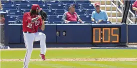  ?? LYNNE SLADKY / AP ?? Nationals pitcher Trevor Williams (32) winds up to throw as the pitch clock counts down during a recent spring training game in West Palm Beach, Florida.