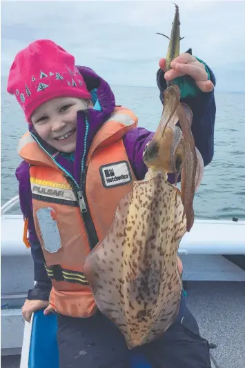  ??  ?? LOOK WHAT I GOT: Sophia Jankowski, 7, with one of the squid she caught at Coles Beacon off the entrance of Swan Bay. Picture: WARREN JANKOWSKI