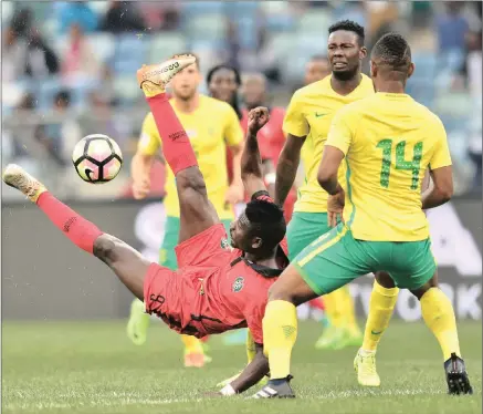  ??  ?? Francisco Santos da Silva Junior of Guinea Bissau is challenged by Eric Mathoho of South Africa during the internatio­nal friendly match at the Moses Mabhida Stadium, in Durban last night.
