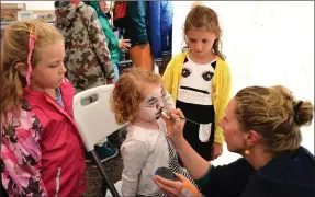  ?? Photo by Declan Malone ?? Artist Ruth Carberry giving Elsie Rose Curran from Tralee a new face, closely watched by Elsie’s sister, Layla, and Sophie Griffin (left), at the West Kerry Show on Sunday.