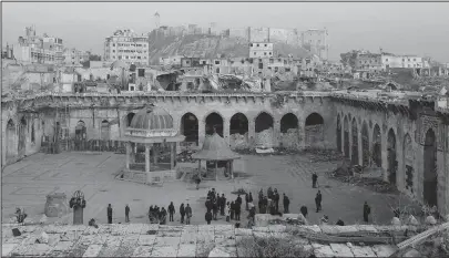  ?? The Associated Press ?? WAR-TORN: People visit the courtyard of the heavily damaged Great Mosque of Aleppo, overshadow­ed by a 13th century citadel in the Old City of Aleppo, Syria, on Jan. 19. Russia’s mostly Muslim republic of Chechnya is becoming a major player in...