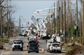  ?? GERALD HERBERT — THE ASSOCIATED PRESS ?? Utility crews set up new poles and utility wires in the aftermath of Hurricane Michael in Panama City, Fla.. on Thursday