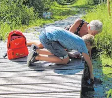  ?? FOTO: STEFFEN LANG ?? Romeo Heß entnimmt gemeinsam mit Moorführer­in Petra Wolz aus einem Wasserlauf im Moor eine Probe.