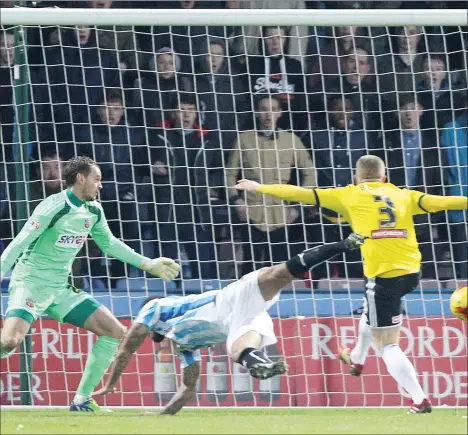  ?? PICTURES: Gordon Clayton ?? IN THE NET: Brentford’s Jake Bidwell can only watch as Sean Scannell scores