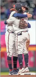  ?? USA Today Sports - Dale Zanine ?? The Braves’ Dansby Swanson (left) and Ozzie Albies hug after the end of Friday night’s win over the Reds at Truist Park.