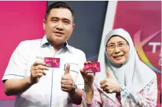  ??  ?? Wan Azizah (right) with Loke shows the discount card during the launching of ‘Kad Diskaun Xtra20 Keretapi Tanah Melayu (KTM) Komuter’. — Bernama photo