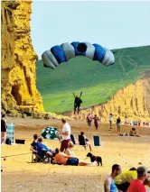  ??  ?? He lands: Beachgoers watch in surprise