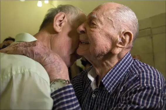  ?? SEBASTIAN SCHEINER — THE ASSOCIATED PRESS ?? Israeli Holocaust survivor Eliahu Pietruszka, right, embraces Alexandre Pietruszka as they meet for the first time in Kfar Saba. Pietruszka who fled Poland at the beginning of World War II and thought his entire family had perished learned that a...