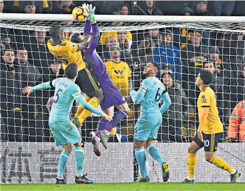  ??  ?? Careless hands: Willy Boly jumps to head in the Wolves equaliser as Newcastle goalkeeper Martin Dubravka fumbles