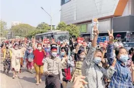  ??  ?? In this image taken from video, protesters flash the three-fingered salute in a symbol of defiance Saturday as they march against military rule in Yangon, Myanmar.