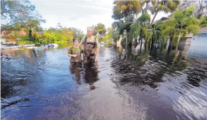  ?? GERALD HERBERT/ASSOCIATED PRESS ?? Kelly McClenthen returns to see the flood damage to her home with her boyfriend, Daniel Harrison, in the aftermath of Hurricane Irma in Bonita Springs, Fla. The scale of the damage inflicted by Irma began to come into focus on Monday.