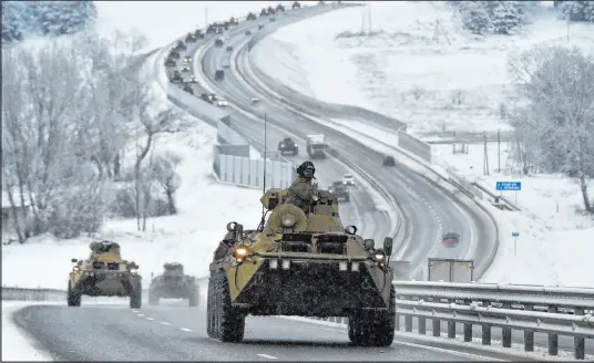  ?? The Asssociate­d Press ?? A convoy of Russian armored vehicles moves along a highway Tuesday in Crimea.