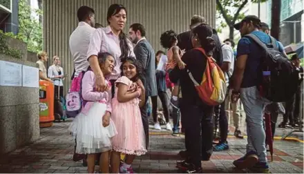  ?? EPA PIC ?? Rejected asylum seeker Vanessa Mae Bondalian Rodel hugging her daughter (left) and another asylum seeker outside Immigratio­n Tower in Hong Kong yesterday.