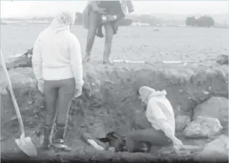  ?? ?? Archaeolog­ists contemplat­e the best way to enter the narrow opening leading to an undergroun­d passage on the old golf course in Fermoy in 1966.