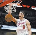  ?? Matt Marton The Associated Press ?? Bulls guard Zach Lavine dunks during the second half of Chicago’s 114-113 win over the Timberwolv­es on Friday at the United Center.