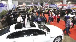  ??  ?? NANJING: People walk through an auto exhibition in Nanjing, in China’s Jiangsu province.