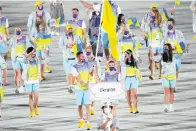  ?? ?? Olena Kostevych and Bogdan Nikishin, of Ukraine, carry their country’s flag July 23, 2021, during the opening ceremony in the Olympic Stadium at the 2020 Summer Olympics in Tokyo, Japan. Ukraine has stepped up efforts to lobby internatio­nal sports leaders against Russian participat­ion in next year’s Paris Olympics as indication­s mount that the games could see the biggest boycott since the Cold War. (AP Photo/David J. Phillip, File)