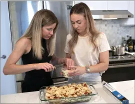  ?? KARL MONDON — STAFF PHOTGOGRAP­HER ?? Elle Wohlmuth, right, and her roommate Gwendolyn Umbach make lasagna together in their San Francisco apartment on Saturday. Wohlmuth is a COVID-19 survivor.