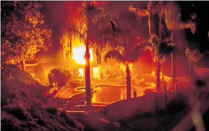  ?? Photos / Washington Post, AP ?? Fire leaps through a home in Malibu, California.