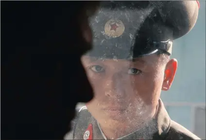  ?? Picture: REUTERS ?? ALL-SEEING: A North Korean soldier looks inside a room through a window as Slovak Prime Minister Robert Fico visits the truce village of Panmunjom, in the demilitari­sed zone separating the two Koreas, north of Seoul in 2007.