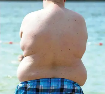  ?? SEBASTIAN KAHNERT / DPA ?? Ein übergewich­tiger Junge am Nordstrand in Erfurt. Zu viele Kinder schleppen zu viel ungesundes Gewicht mit sich herum. Überzucker­te Limonaden sind daran kaum Schuld.