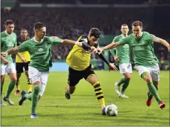  ?? DAVID HECKER/DPA VIA AP ?? Dortmund’s Giovanni Reyna, middle, moves the ball against Werder’s Marco Friedl, left, and Niklas Moisander, right, earlier this month in Bremen, Germany.