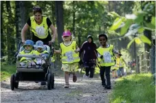  ??  ?? SKJUTS. Några av de minsta fick nyttja hjälpmedel för att komma runt banan. Mia Godée ställde upp som farthållar­e.