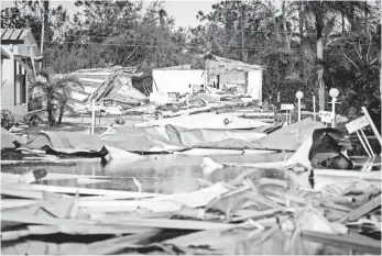  ?? RODNEY WHITE, USA TODAY NETWORK ?? Debris is scattered among flooded streets Monday at Naples Estates trailer park in East Naples, Fla.