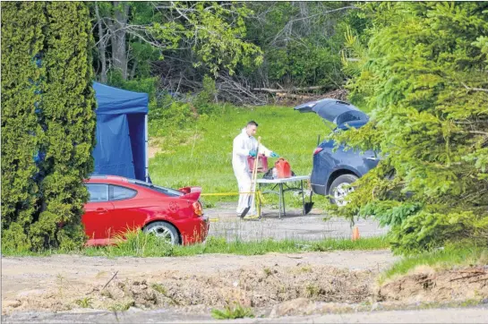  ?? COLIN CHISHOLM ?? RCMP officers go through the scene of a fatal structure fire on South Rawdon Road in April.