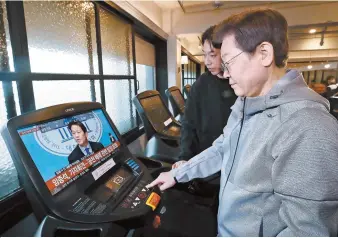  ?? Joint Press Corps ?? Rep. Lee Jae-myung, chairman of the main opposition Democratic Party of Korea (DPK), watches a TV screen on a treadmill during his visit to a gym in Eunpyeong District, Seoul, Wednesday. The monitor shows former presidenti­al chief of staff Im Jong-seok holding a press conference at the National Assembly.