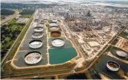  ?? FILE PHOTO BY TOM FOX/THE DALLAS MORNING NEWS VIA AP ?? Large storage tanks in retention ponds are surrounded by rainwater left behind by Tropical Storm Harvey at ExxonMobil’s refinery in Baytown, Texas.