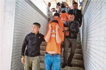  ?? PIC BY KHAIRULL AZRY BIDIN ?? Three of the accused being led to the magistrate’s court in Kota Kinabalu yesterday.