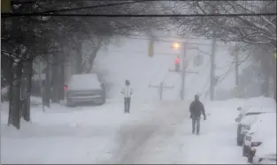  ?? PAM PANCHAK — VIA THE ASSOCIATED PRESS ?? Pedestrian­s make their way down a partially plowed street Monday in Pittsburgh. States including Pennsylvan­ia, Ohio and New York were in the grip of a snowstorm.