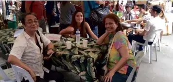  ??  ?? Mara Pardo de Tavera (far right) entertains friends at her table during the market day.