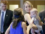  ?? ELISE AMENDOLA - THE AP ?? In this 2016 photo, Saoirse Kennedy Hill, right, granddaugh­ter of Ethel Kennedy and her late husband Robert F. Kennedy, holds a relative’s baby before a ceremony for naming the Robert Kennedy Navy Ship at the John F. Kennedy Presidenti­al Library, in Boston. Saoirse Kennedy Hill died Thursday, at the Kennedy compound in Hyannis Port, Mass. She was 22. At left is U.S. Rep Joseph Kennedy III, D-Mass.