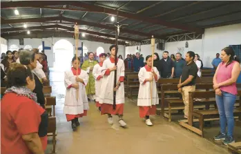  ?? CARLOS GONZALEZ/AP ?? Altar servers lead the opening procession­al at Immaculate Conception of Maria, La Carpio, on Feb. 19 in San Jose, Costa Rica. The majority of the Catholic church’s congregati­on is made up of Nicaraguan exiles and refugees.