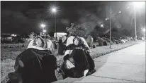  ?? [ANDREW WEST/FORT MYERS NEWS-PRESS] ?? Terri Kado, 66, (right) and Patty Tubbs, 68, wait in line for a COVID-19 vaccine in the early morning hours of Dec. 30 at Lakes Park Regional Library in Fort Myers, Fla. They got in line at midnight.