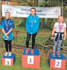  ??  ?? Arran’s Ciara Wood on the podium after winning silver in the S3 girls category at the British Schools Orienteeri­ng Score Championsh­ips