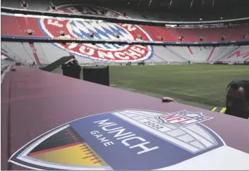  ?? AP PHOTO/MATTHIAS SCHRADER ?? Workers prepare a sign inside the FC Bayern Munich soccer stadium Allianz Arena in Munich, Germany, on Nov. 9.