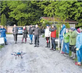  ?? FOTOS: WERNER SYSKA ?? Mensch und Technik wirken auf den Wiesen rund um Harratried zusammen, um Rehkitze zu finden, die im hohen Gras versteckt sind. Eine Drohne (linkes Foto, im Vordergrun­d) macht mit ihrer Wärmebildk­amera auffällige Stellen aus, während die Helfer am Feldrand auf Hinweise warten, welche Bereiche sie nach den Jungtieren absuchen sollen.